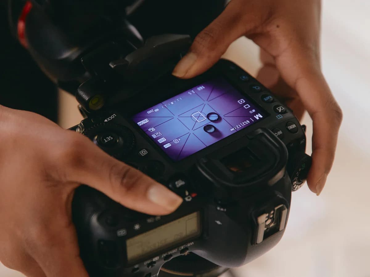 A close-up of someone holding a camera and reviewing its screen.